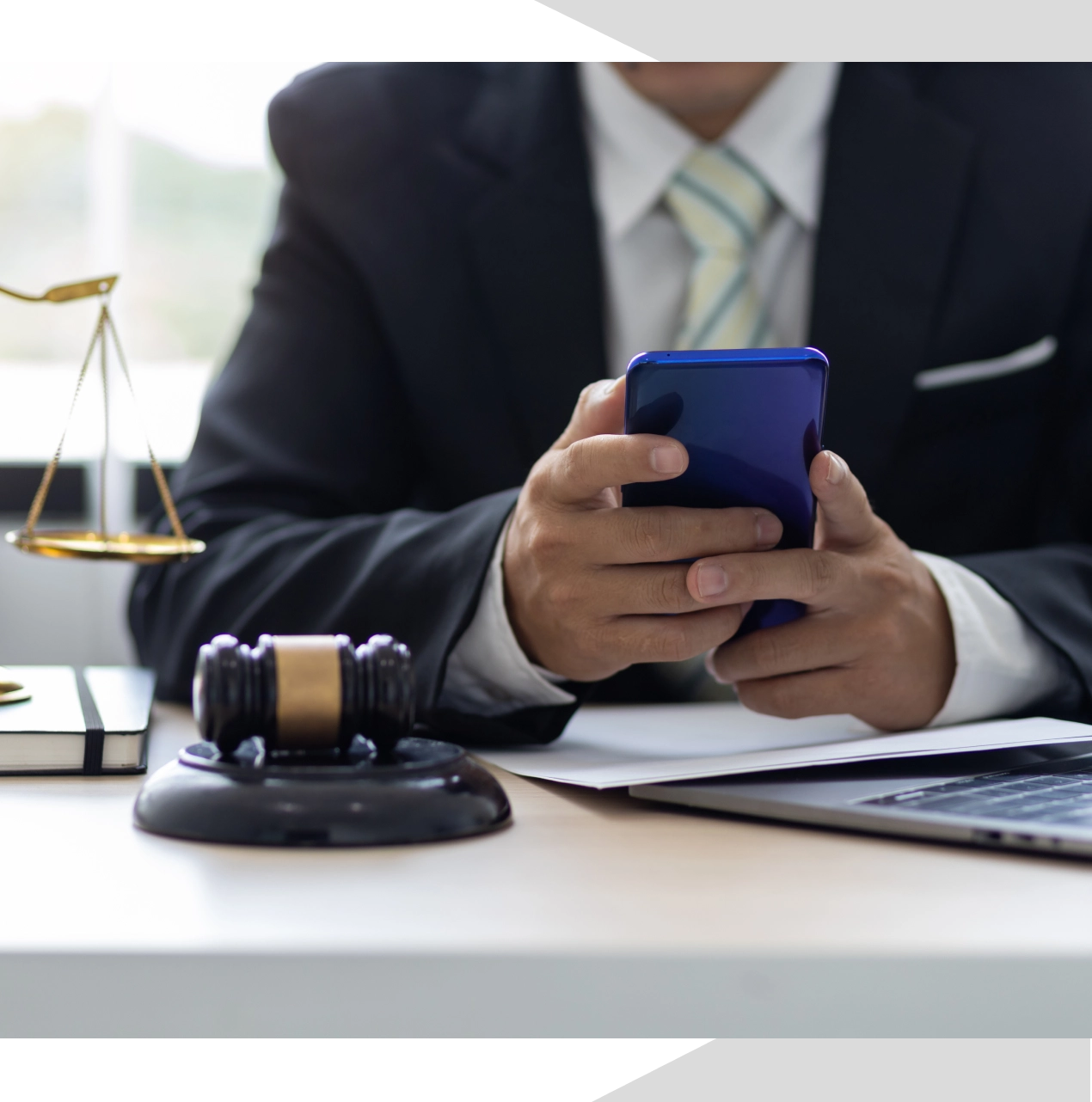 A man in suit and tie holding a cell phone.